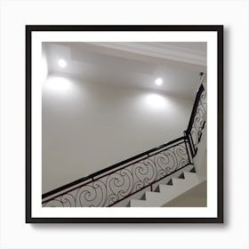 The staircase is characterized by its winding trails that lead up to the next level. The walls are painted in a pristine white color, which gives the space a modern and sleek feel. Soft lighting illuminates the stairs, providing a warm and welcoming atmosphere. Art Print