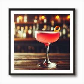 A beautiful, refreshing, and delicious pink cocktail with an orange twist, sitting on a wooden bar counter against a blurred background of a bar with bottles and glasses Art Print