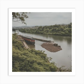 A Train Passes In Front Of The River With Green Trees Art Print