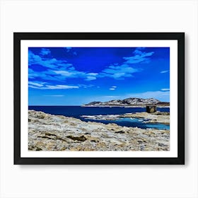 Rocky Coastal Landscape in Sardinia. A serene coastal landscape. The foreground features a rocky shoreline, with the ocean stretching out in the distance. A small, weathered stone tower stands on a rocky outcropping, adding a sense of history and mystery to the scene. The sky is filled with soft, fluffy clouds, creating a peaceful and contemplative atmosphere. Art Print