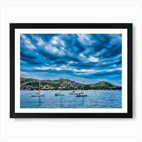 Sailboats at Anchor in Esterel France. The image captures a serene scene of several sailboats anchored in a calm bay. The boats are white with their masts raised, suggesting a peaceful and tranquil atmosphere. The water is a deep blue, reflecting the overcast sky above. The background features a picturesque coastline with rolling hills covered in lush greenery and dotted with houses. Art Print