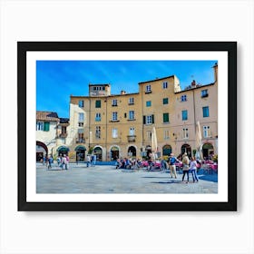 Piazza dell'Anfiteatro in Lucca. The vibrant Piazza dell'Anfiteatro in Lucca, Italy, is a unique elliptical square built on the remains of an ancient Roman amphitheater. Surrounded by colorful historic buildings, the square is bustling with life, featuring outdoor cafes, shops, and visitors enjoying the lively atmosphere. 1 Art Print