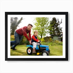 A Man Pushing A Young Boy On A Toy Tractor Art Print