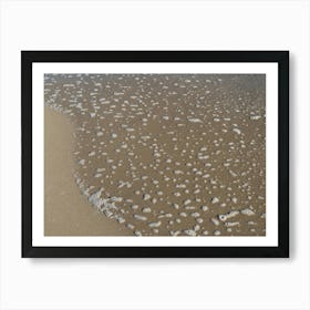 Foaming sea water and sand on the beach Art Print