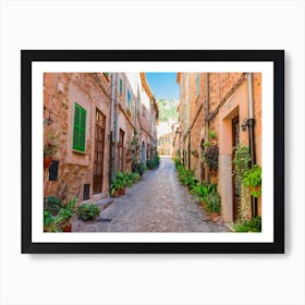 Beautiful street at the mediterranean village of Valldemossa on Majorca Spain. Wander through beautiful streets lined with historic buildings adorned with blooming flowers and lush plants. Admire the intricate architecture and facades of the old houses, and feel the romance in the air. Art Print