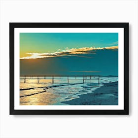 Sunset Pier in Riviera. The image depicts a wooden pier extending into a calm sea at sunset. The sky is a vibrant blend of blue and orange, with fluffy clouds casting long shadows on the water. The pier is made of dark wood and has a railing along its sides. The water is a tranquil turquoise, reflecting the warm hues of the setting sun. Art Print