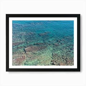 Aerial view of clear sea water and rocky shore Art Print