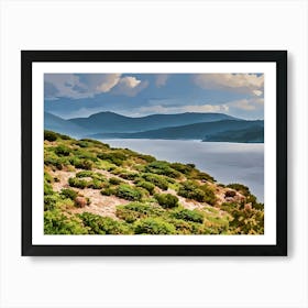 Green coastal landscape in Sardinia. This image showcases a lush, green coastal landscape with low bushes and rocky terrain in the foreground, leading to a calm, reflective sea. Behind the water, gentle hills rise, creating layers of soft blue and green hues under a partly cloudy sky. The scene is peaceful and captures the natural beauty of Sardinia’s coastal environment. Art Print