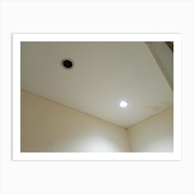 The ceiling is white and has two holes for light bulbs, but only one of them is currently lit. Art Print