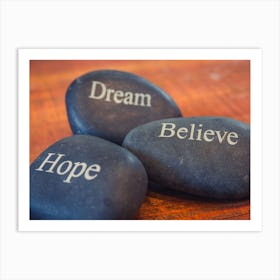 Black Inspirational Pebble Stones With The Words Dream, Believe And Hope On Wooden Background Art Print
