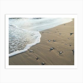 Gentle waves meet the sandy beach Art Print