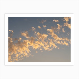 Golden clouds in the pale blue sky at sunset Art Print