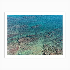 Aerial view of clear sea water and rocky shore Art Print