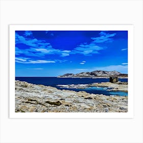 Rocky Coastal Landscape in Sardinia. A serene coastal landscape. The foreground features a rocky shoreline, with the ocean stretching out in the distance. A small, weathered stone tower stands on a rocky outcropping, adding a sense of history and mystery to the scene. The sky is filled with soft, fluffy clouds, creating a peaceful and contemplative atmosphere. Art Print