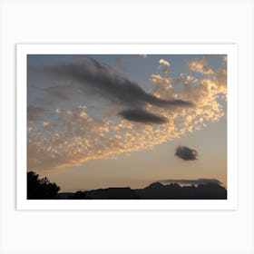 Cloudy sky and mountain silhouette at sunset Art Print