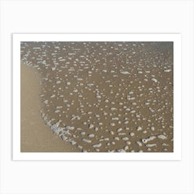 Foaming sea water and sand on the beach Art Print