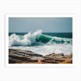 A Wave Crashing Onto The Ocean Rocks Art Print