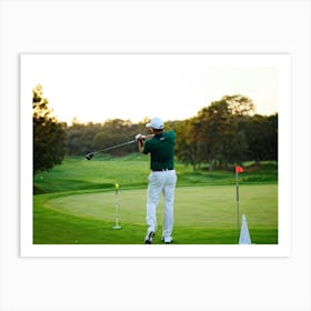 Evening Glow Softly Embracing A Serene Golf Course As A Golfer Swings A White Driver Amidst The Acti (2) Poster