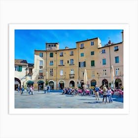 Piazza dell'Anfiteatro in Lucca. The vibrant Piazza dell'Anfiteatro in Lucca, Italy, is a unique elliptical square built on the remains of an ancient Roman amphitheater. Surrounded by colorful historic buildings, the square is bustling with life, featuring outdoor cafes, shops, and visitors enjoying the lively atmosphere. 1 Art Print