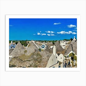 Trulli Houses in Italy. The image showcases a picturesque view of a traditional Italian village, featuring a cluster of Trulli houses with their distinctive conical roofs. The houses are constructed from white stone and have a rustic charm, with some roofs adorned with intricate patterns. The scene is bathed in warm sunlight, with a clear blue sky and fluffy white clouds overhead. Art Print