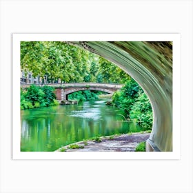 Tranquil Pathway Canal de Brienne Toulouse France. This image captures a tranquil riverside scene viewed from beneath a bridge. The lush greenery of the trees and bushes reflects beautifully on the calm, green-tinted water. In the background, another stone bridge spans the river, adding to the picturesque and serene atmosphere of the setting. Art Print