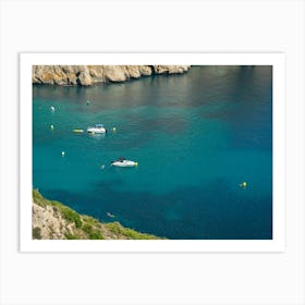 Sea water, cliffs and boats in a bay Art Print