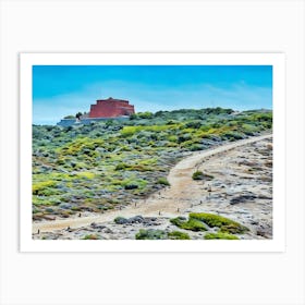 Path to the Red Fortress. A winding path leads through a rugged, green-dotted landscape to a striking red fortress perched atop a hill, blending history with natural beauty under a vivid blue sky. Art Print