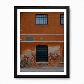 Bike in the street against an orange wall Art Print