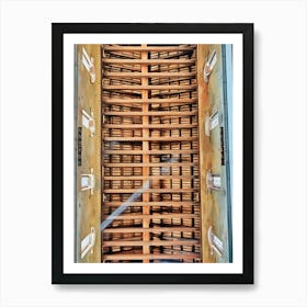 Architectural Ceiling Design. This image showcases an intricately designed ceiling, featuring a series of wooden beams arranged in a grid pattern. The beams create a sense of depth and structure, with light filtering through the gaps, casting shadows that enhance the three-dimensional effect. The sides of the ceiling are adorned with decorative elements resembling windows, adding to the architectural beauty and complexity of the design. Art Print