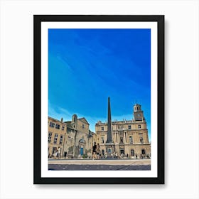 French Town Square. A wide shot captures a bustling town square in France, bathed in the warm glow of a sunny day. The sky is a vibrant blue, contrasting with the pale stone buildings that line the square. A tall obelisk stands prominently in the center, surrounded by a crowd of people. The buildings feature classic French architecture, with arched doorways, ornate windows, and a clock tower. Art Print