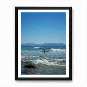 Surfer On The Beach With Surfboard Amongst Blue Skies, Rocks And Mountain Background In Byron Bay, Queensland Art Print