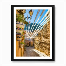 Spain, Valldemossa fiestas, lose yourself in the narrow, rustic streets of Valldemossa, a charming old village in Mallorca, Spain. Admire the Mediterranean stone buildings adorned with potted plants and flowers, showcasing the rich Balearic Island culture and history. Art Print