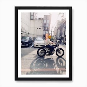 A Man Riding A Motorcycle In A City Art Print