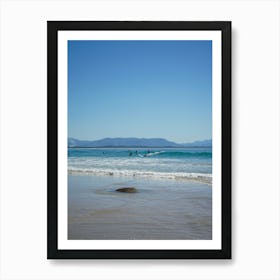 Surfers On The Beach In Popular, Byron Bay. Town And Mountains In The Background, In The Distance Over The Ocean Art Print