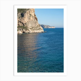 Cliffs and subtle reflections in clear sea water Art Print