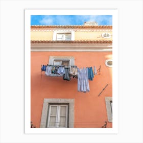 Laundry on a line in Alfama, Lisbon, Portugal with an orange stucco wall. Summer nature and travel photography by Christa Stroo Art Print