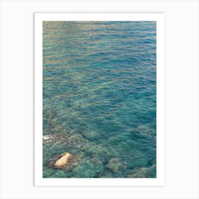 Clear sea water and reflections in a rocky bay Art Print