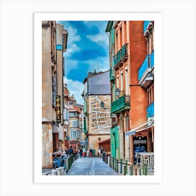 Toulouse Carmes Charming European Street with Colorful Buildings. Toulouse Carmes France. This image depicts a picturesque European street lined with colorful buildings. The street is narrow and paved, with people walking and engaging in various activities. The buildings are adorned with balconies and vibrant facades, creating a lively and inviting atmosphere. A large mural is visible on one of the buildings, adding an artistic touch to the scene. The sky is clear with a few clouds, enhancing the overall charm of the setting. Art Print