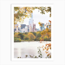 New York, USA I Central Park lake in the nature with autumn aesthetic and pastel orange tones in the wild tree leaves with the New York skyline, its skyscraper buildings and grandiose architecture photography Art Print