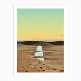 Beach Path at Sunset in Riviera. A digital illustration depicts a sandy beach at sunset, with a long, narrow wooden path leading towards the horizon. The sky is a gradient of soft blue, yellow, and orange, creating a peaceful and serene atmosphere. The path is made of light-colored wood planks, and it is surrounded by brown sand with footprints leading towards it. Art Print