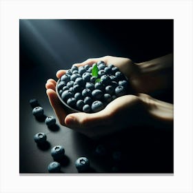 Close-up of a Hand Holding a Bowl of Blueberries with a Single Green Leaf in the Center of the Berries and a Few Blueberries Scattered on the Dark Surface Below the Bowl Canvas Print