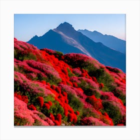 A Large Mountain With Red Flowers Stacked Below It And A Wide Blue Sky In The Background With No Tre (1) Canvas Print