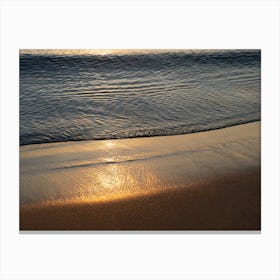 Sunrise and golden reflections at the beach Canvas Print