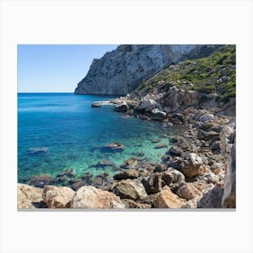 Turquoise sea water and rocky beach Canvas Print