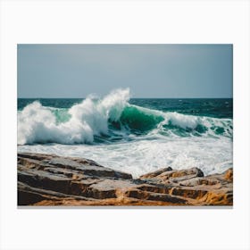 A Wave Crashing Onto The Ocean Rocks Canvas Print