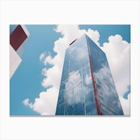 A Modern Skyscraper Made Of Glass Reflects The Blue Sky And Puffy White Clouds Above Canvas Print