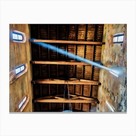 Heavenly Light. A captivating view of a wooden church ceiling in Pisa, with natural light streaming through small arched windows. The interplay of light and shadows highlights the intricate beams and aged walls, creating a serene and spiritual atmosphere. Canvas Print