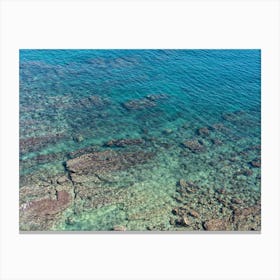 Aerial view of clear sea water and rocky shore Canvas Print