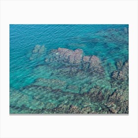 Aerial view of rocks and blue sea water Canvas Print