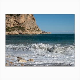 Foaming sea water and cliffs on the beach Canvas Print